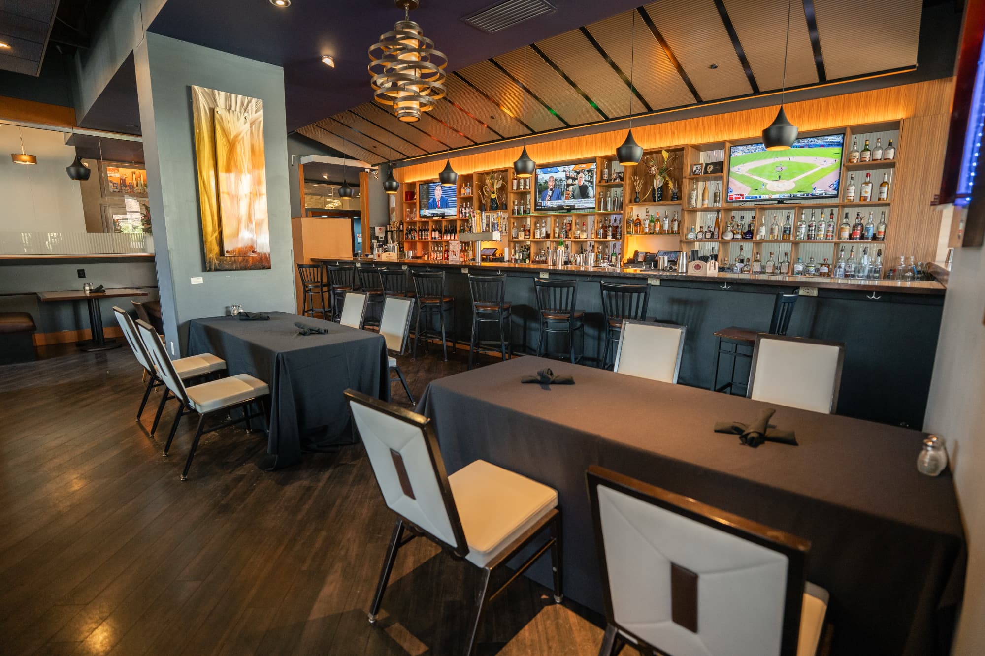 The interior of the Eclipse Restaurant, showing a few empty tables and a bar with a glow of ambient lighting