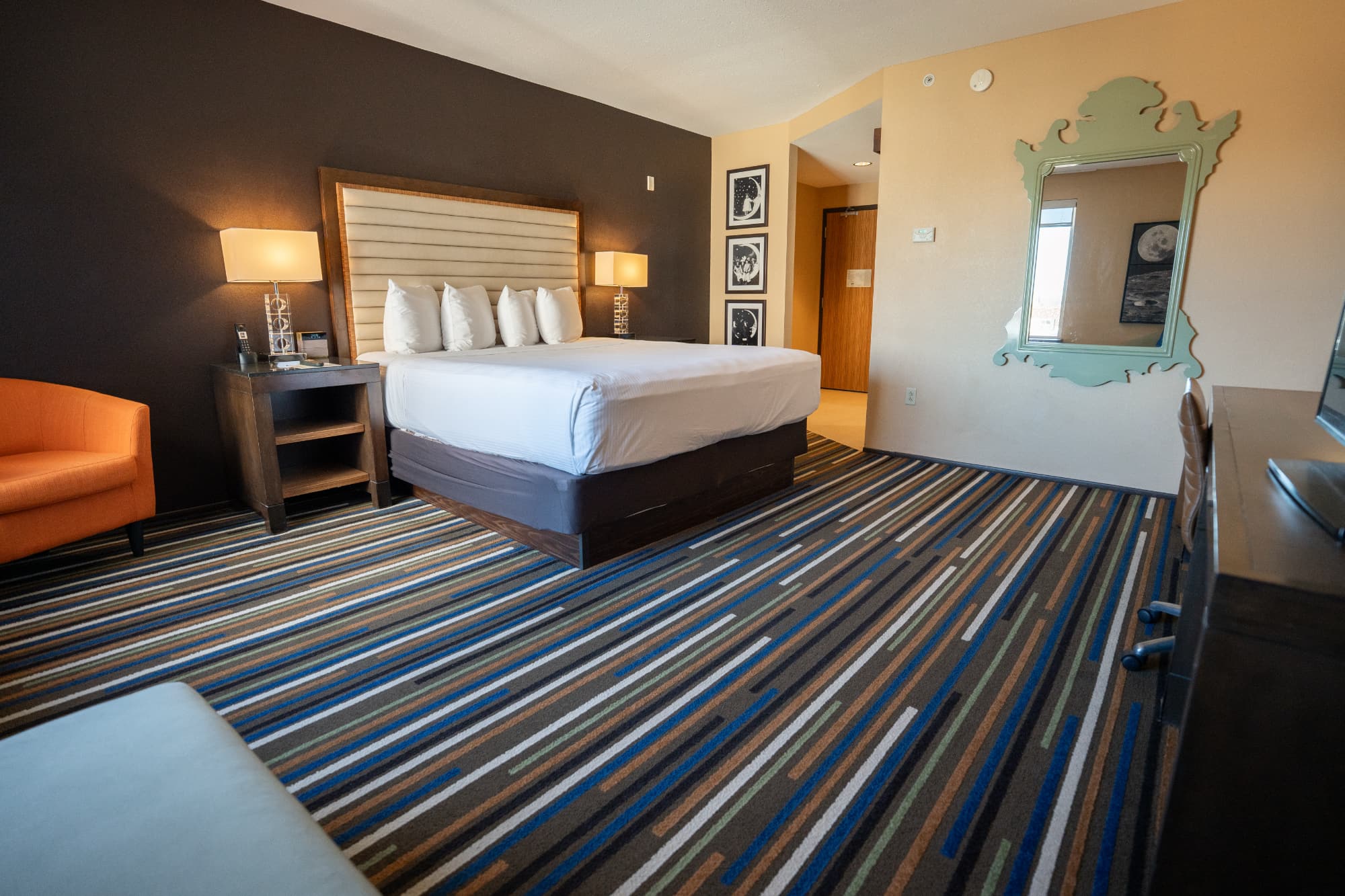A boutique hotel room with a king size bed and funky mirror at the Moonrise Hotel in St Louis