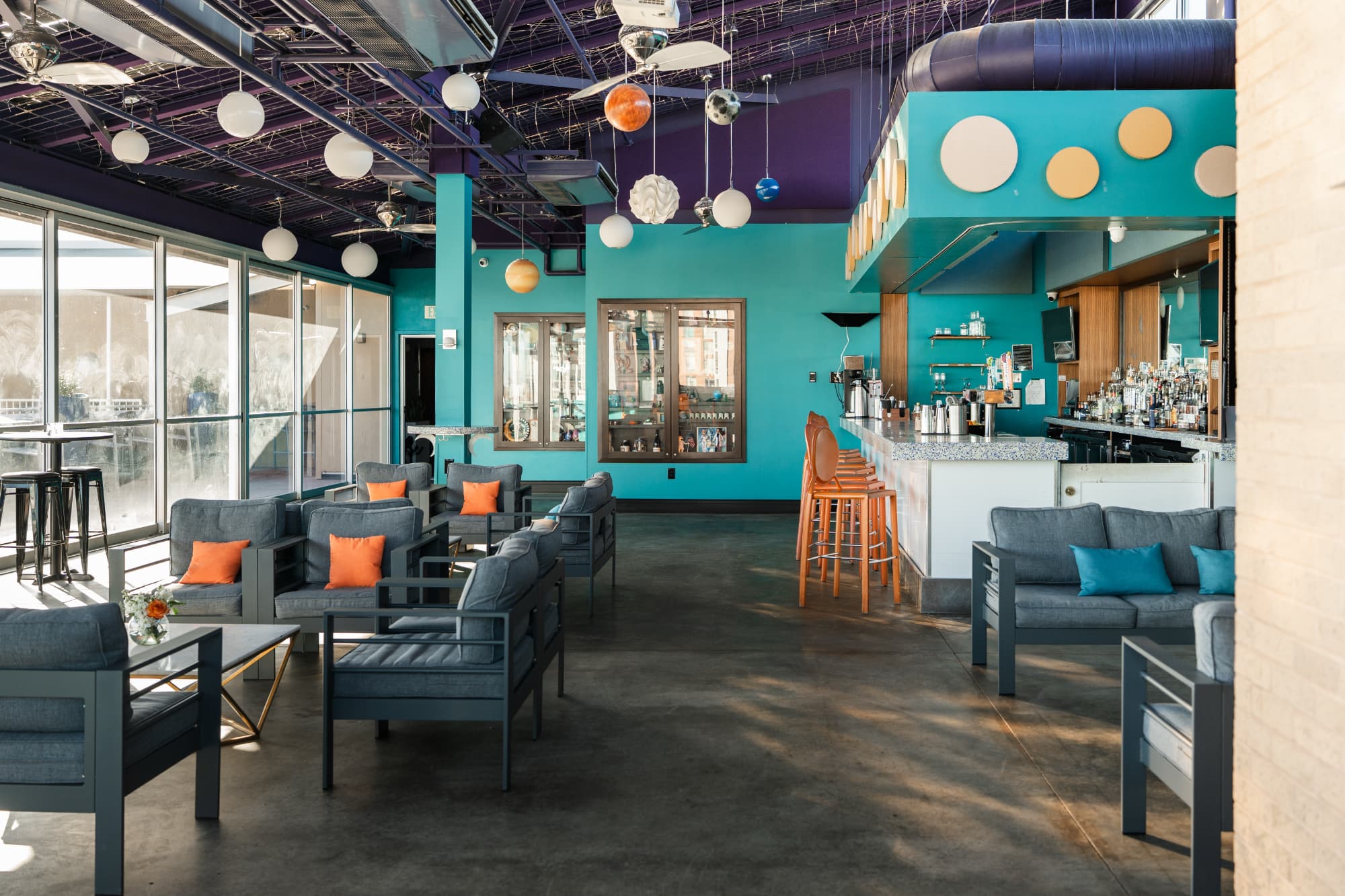 The interior of the rooftop twilight room, a colorful teal and purple room with a bar and tables