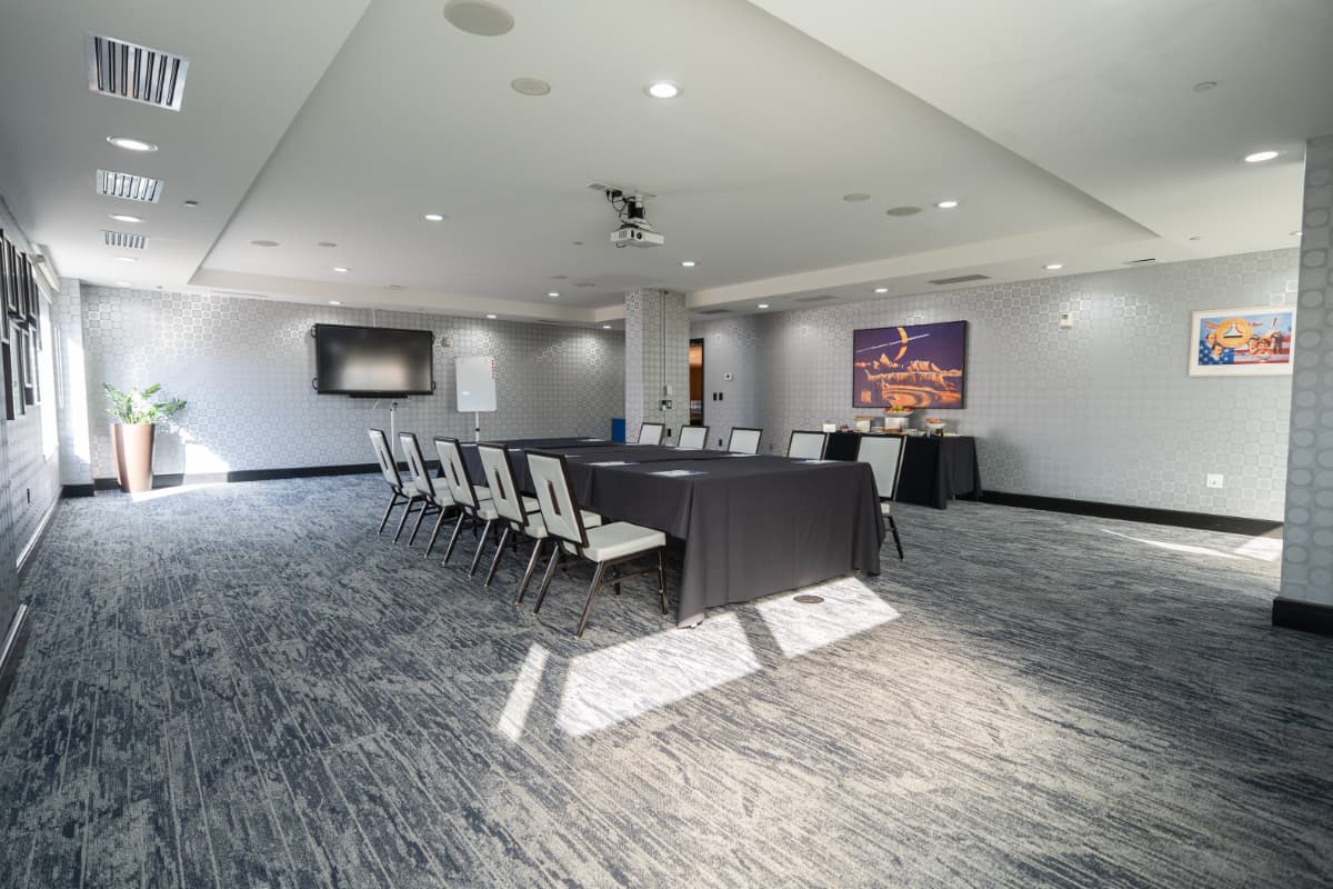 apollo 8 A meeting room with a long conference table covered with a black tablecloth and 10 chairs surrounding it.