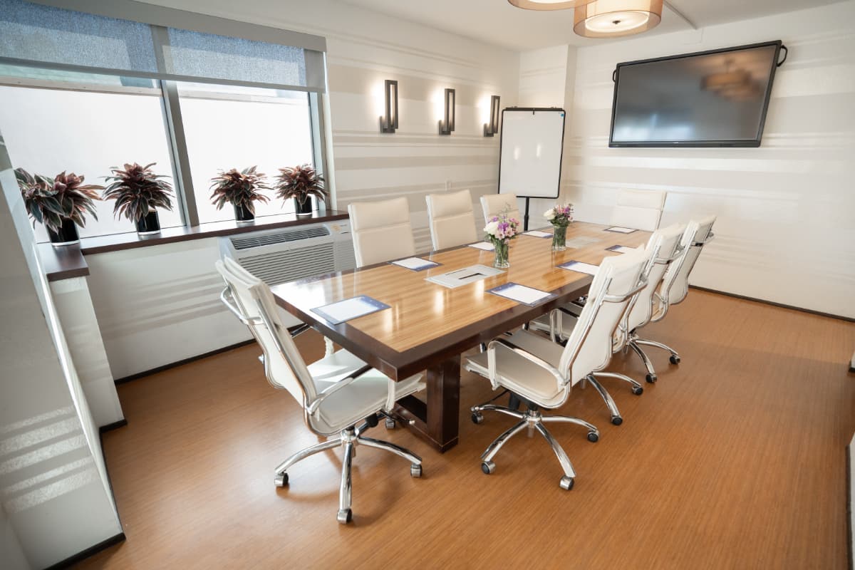 boardroom A meeting room with a small conference table, 8 chairs around it, and a tv hanging on the wall.