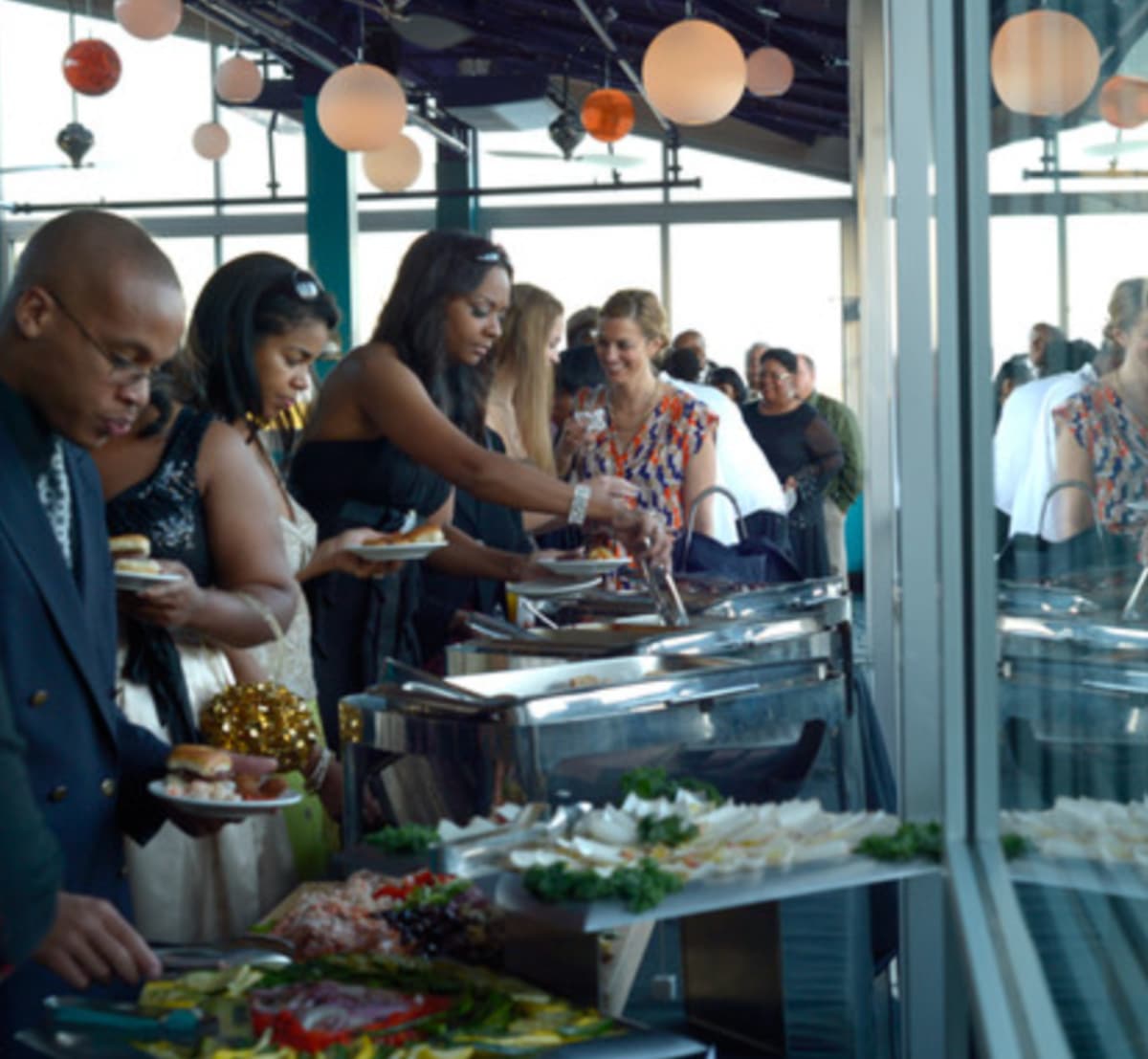 catering at wedding People line up and scoop the food from the buffet onto their plates.