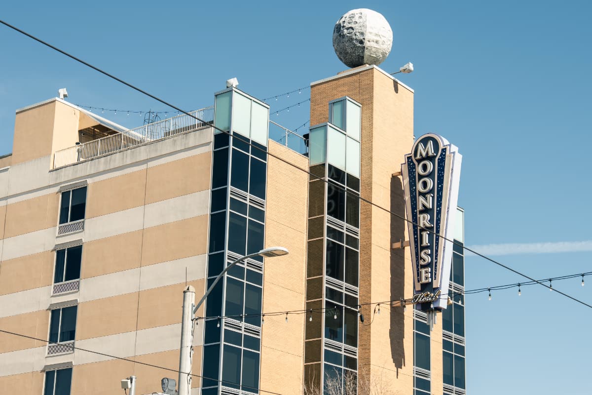 A close up of the Moonrise Hotel sign and the moon statue on the roof taken from across the street.