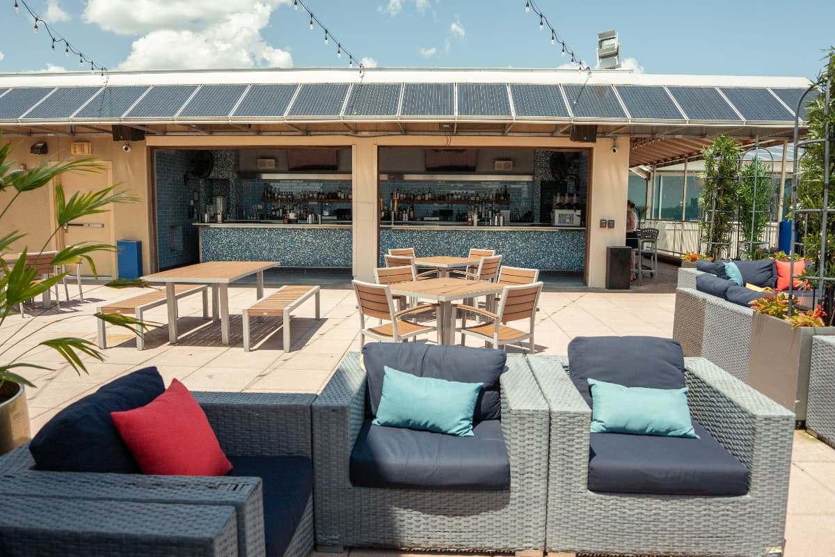 view of bar Couches and tables are arranged in front of a covered outdoor bar