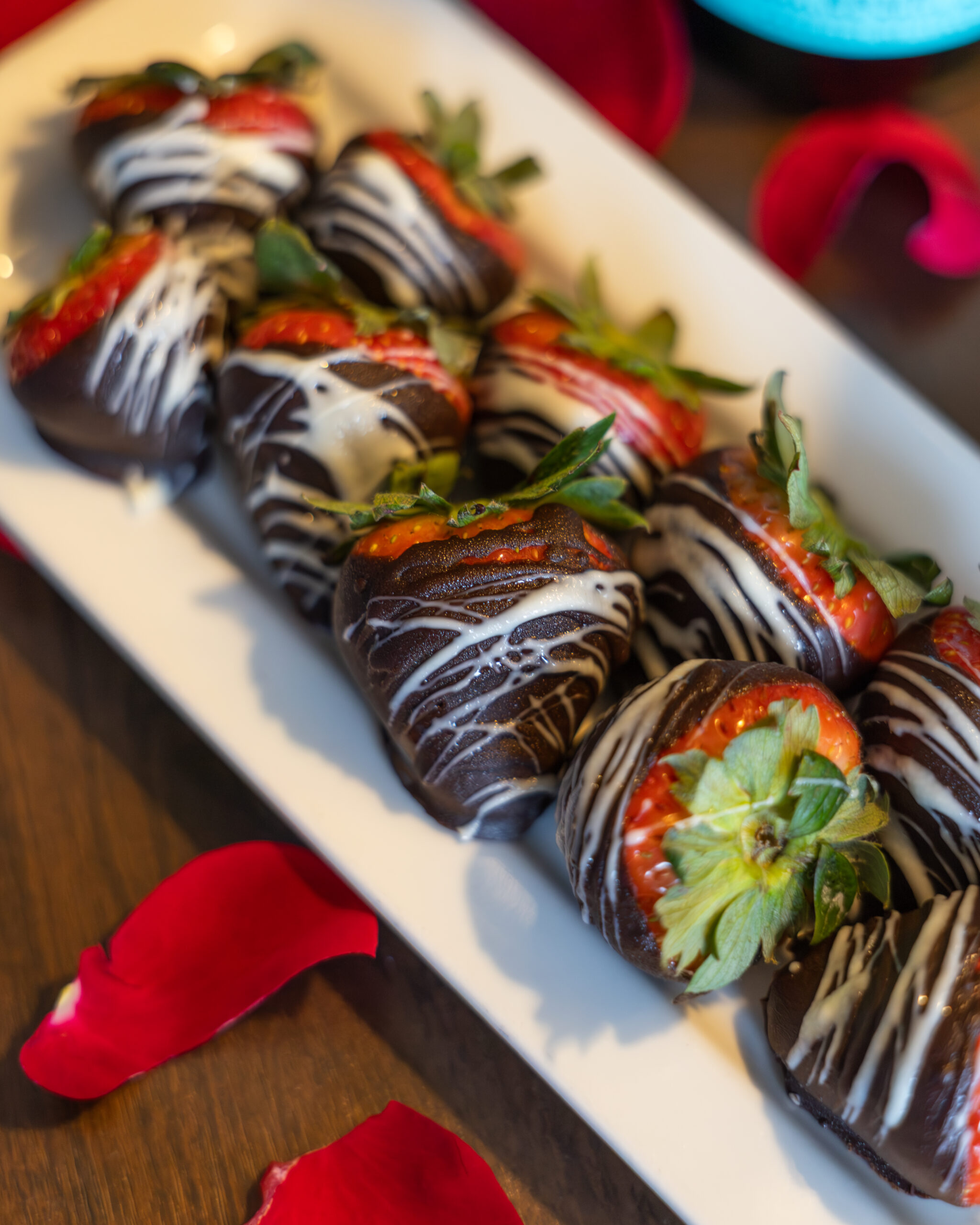 A bottle of champagne chills in an ice container, and two empty champagne flutes sit next to it. The rest of the hotel room is in the background.